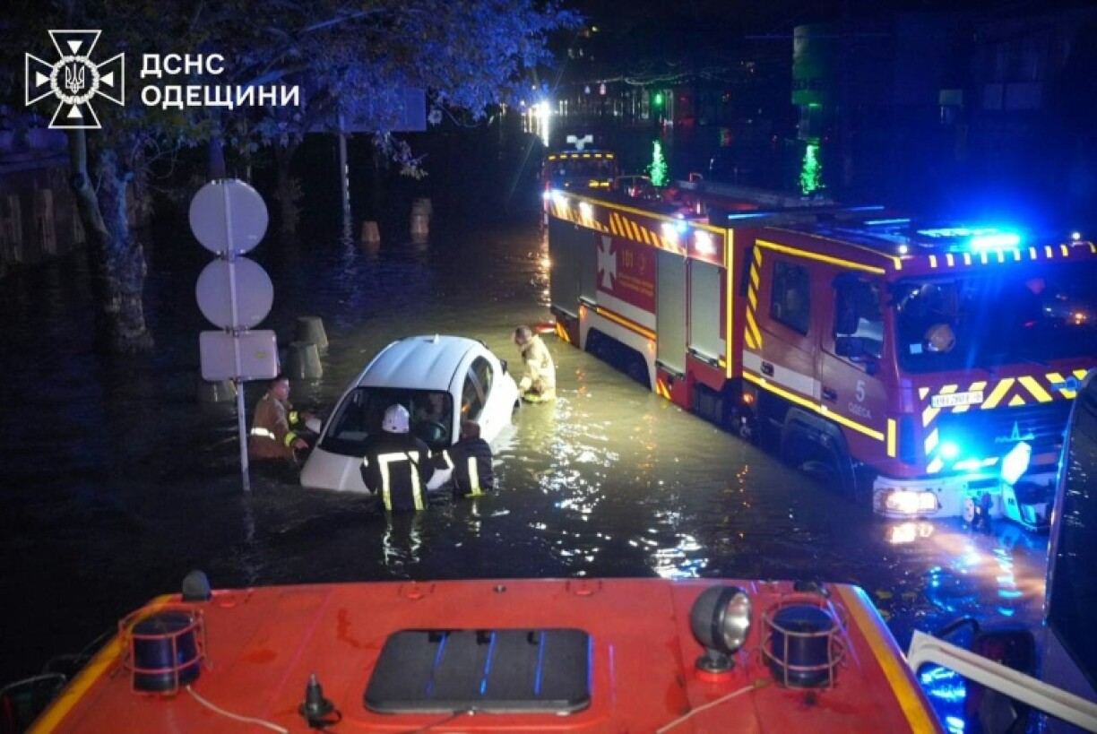 Rescuers push a car through the flooded streets of Odesa