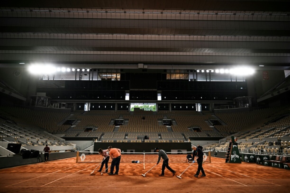Round-the-clock care: Crew members work under the lights to keep the courts properly maintained