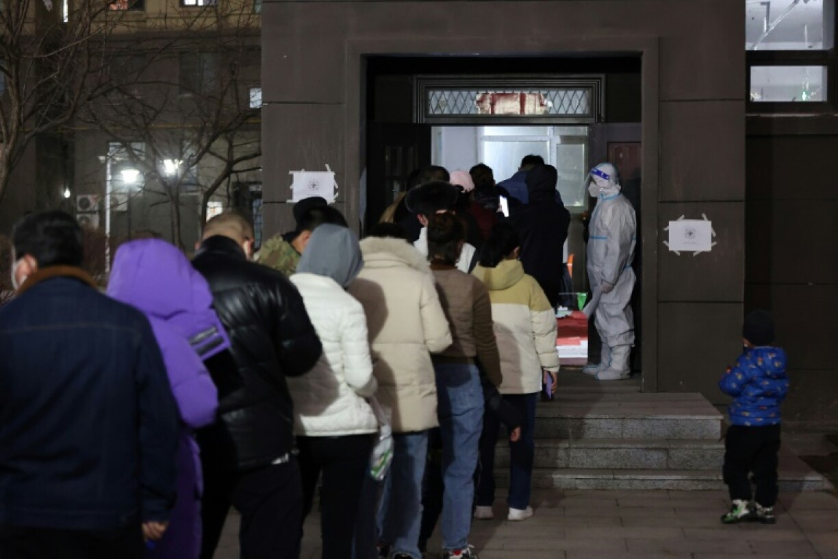 Des habitants d'un quartier résidentiel de Changchun, en Chine, font la queue pour se faire dépister le 11 mars 2022