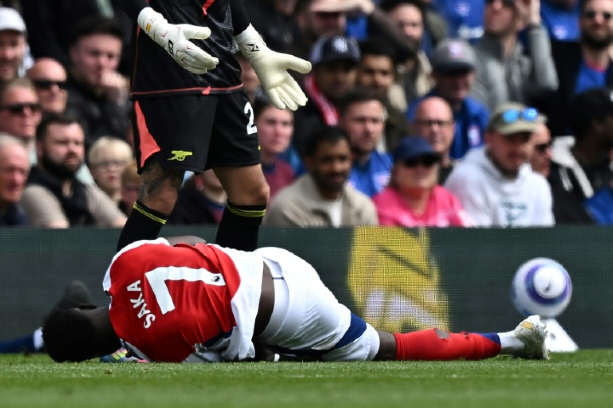Arsenal's Bukayo Saka lies injured after Leif Davis's foul at Ipswich