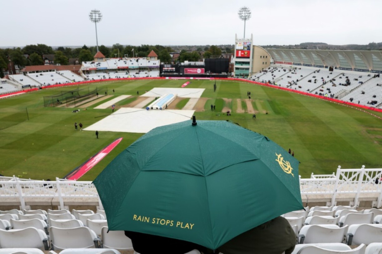 A spectators sits under an umbrella as rain washes out the third T20 between England and South Africa at Trent Bridge without a ball being bowled