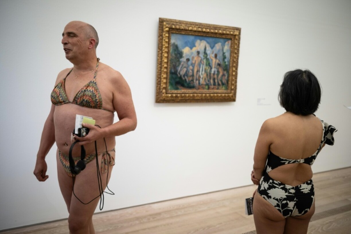 Des visiteurs en maillot de bain devant les "Baigneurs" (1890) de Paul Cézanne, lors d'un événement inspiré par l'artiste italien Maurizio Cattelan à la fondation Beyeler, près de Bâle, en Suisse, le 1er mai 2026