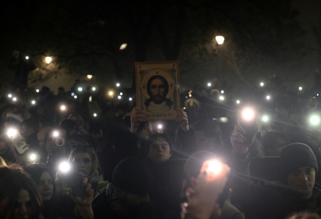 A protestor holds an orthodox icon as a thousands of students attend a protest on New Year's Eve