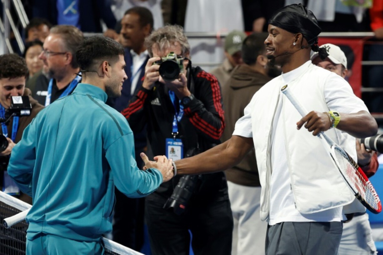 Carlos Alcaraz (left) shakes hands with Jimmy Butler as they put on a bonus show for fans in Doha