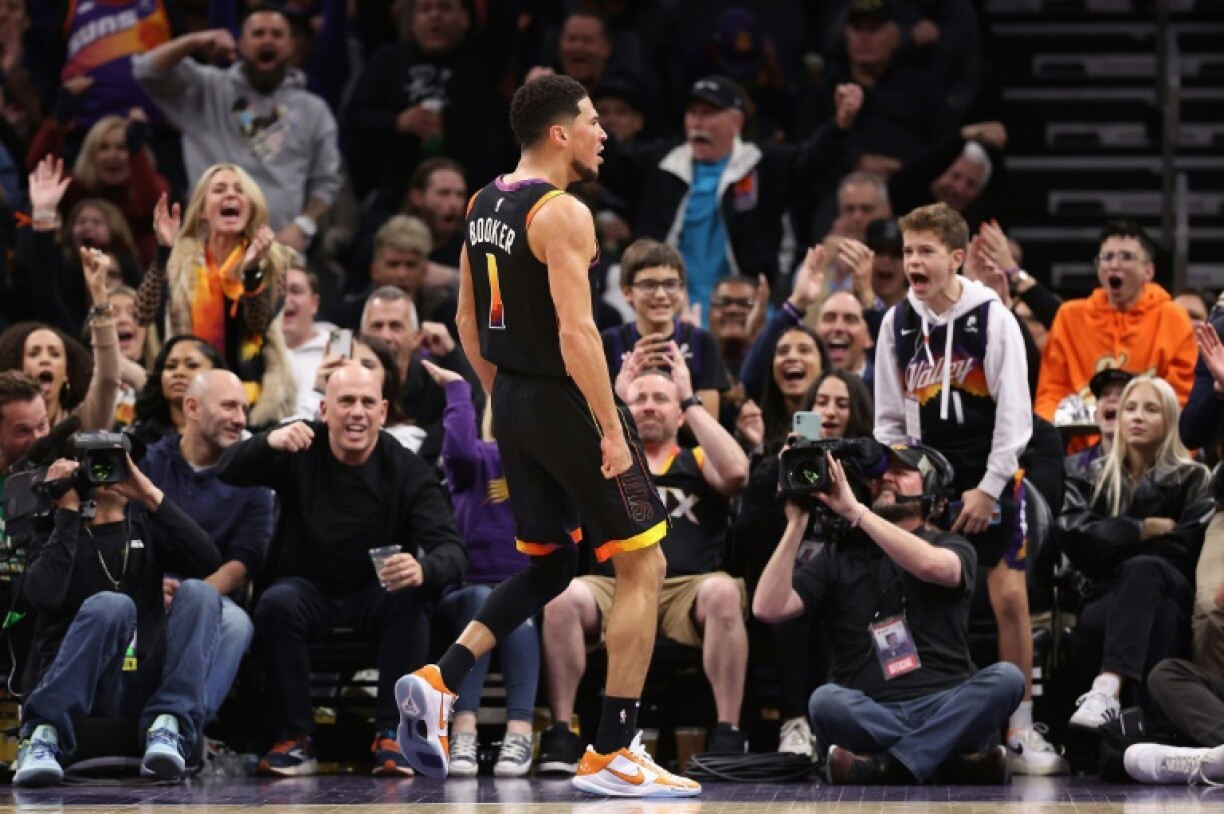 Devin Booker et des fans des Suns exultent après un panier inscrit par le joueur, lors d'un match de NBA contre la Nouvelle-Orléans, le 17 décembre 2022 à Phoenix