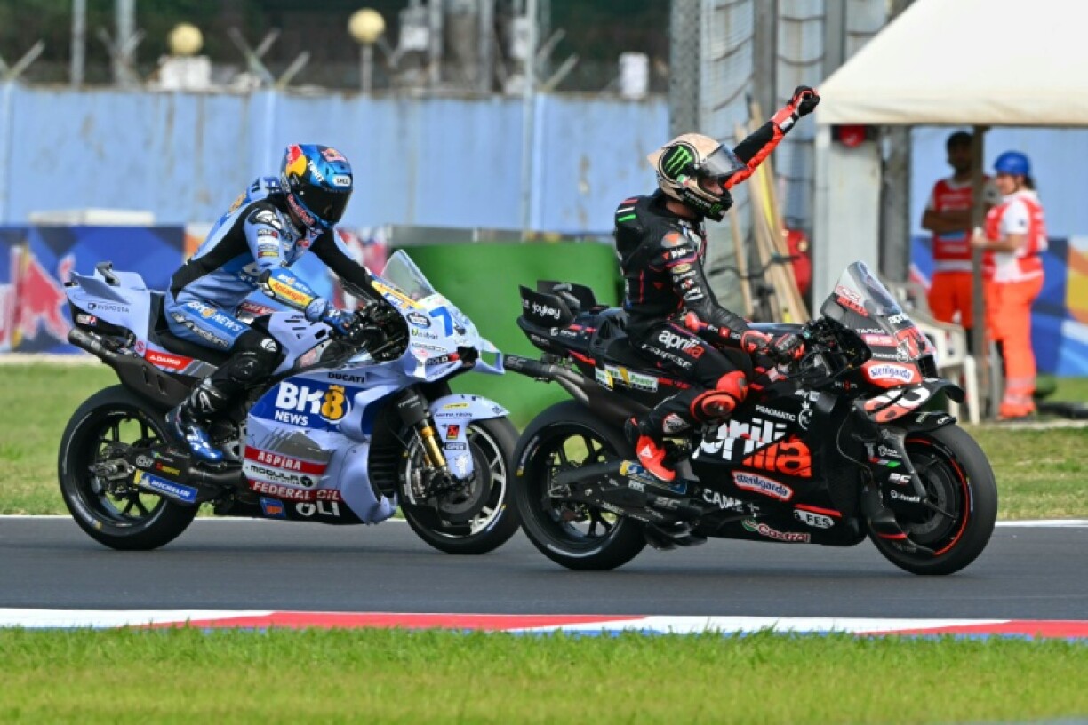 Aprilia Racing team's Italian MotoGP rider Marco Bezzecchi (R) celebrates after winning the San Marino Moto GP Sprint Race