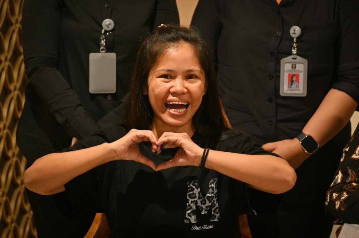 Mary Jane Veloso makes a heart gesture with her hands at a ceremony marking her transfer to Philippine authorities