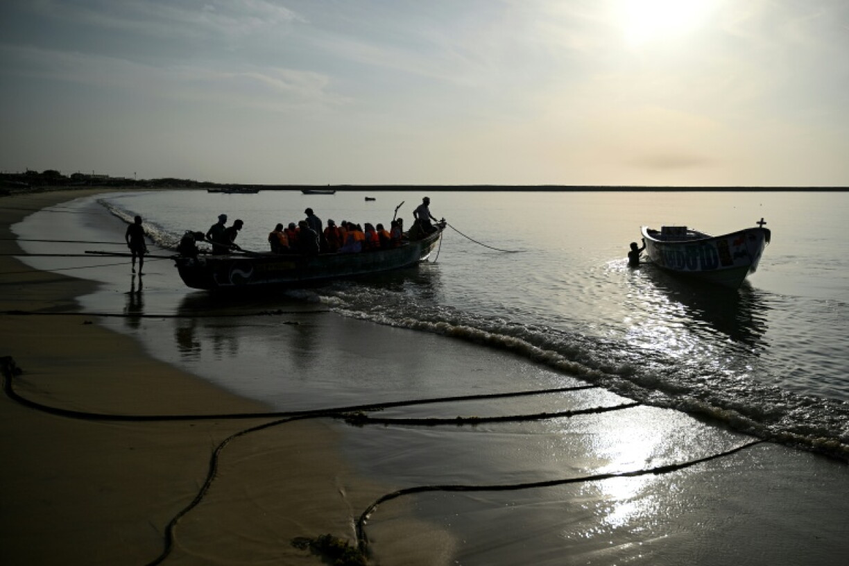 Fishing community members get into a boat to travel to Kariyachalli Island, off the coast of Thoothukudi in India's Tamil Nadu state