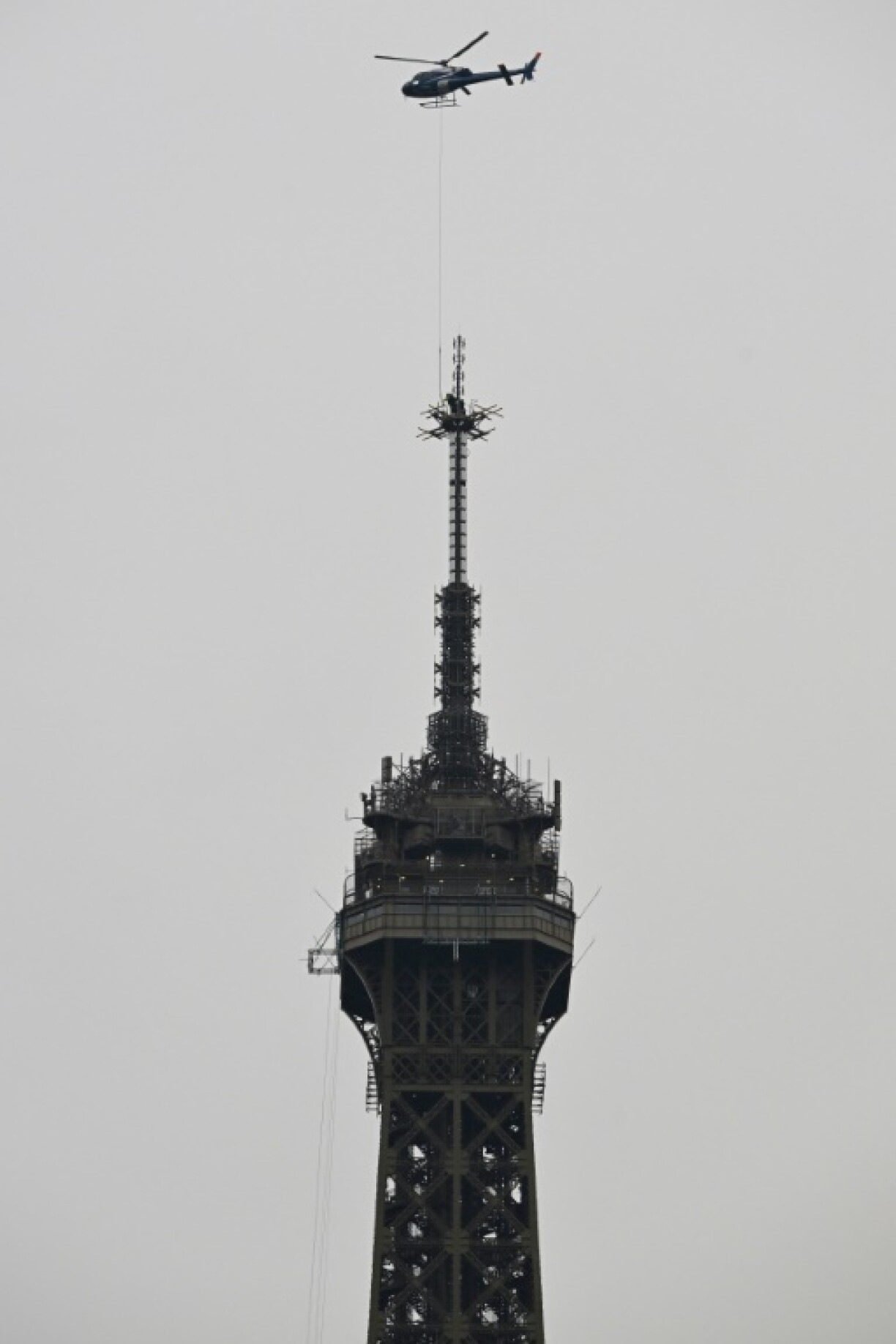 Une antenne radio de six mètres de hauteur est hélitreuillée au sommet de la Tour Eiffel, le 15 mars 2022 à Paris