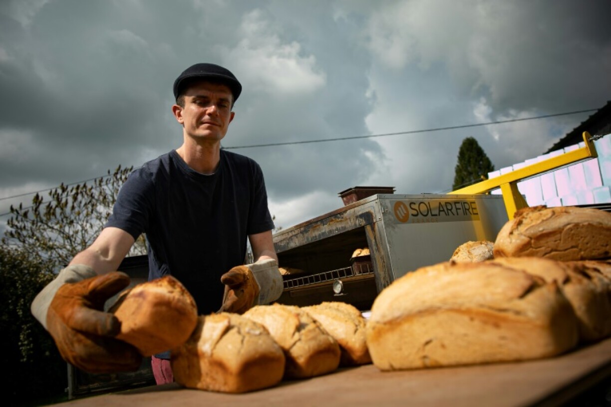 Le boulanger-torréfacteur Arnaud Crétot sort son pain qui a cuit dans un four solaire, le 2 mai 2023 à Montville, près de Rouen, en Normandie