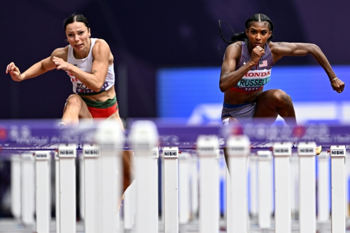 Hungary's Luca Kozak (L) and American Masai Russell compete in the women's 100m hurdles heats