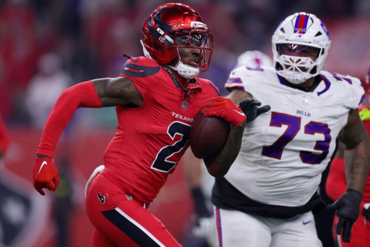 Houston's Calen Bullock, left, runs with an intercepted pass in the Texans' 23-19 NFL triumph over Buffalo