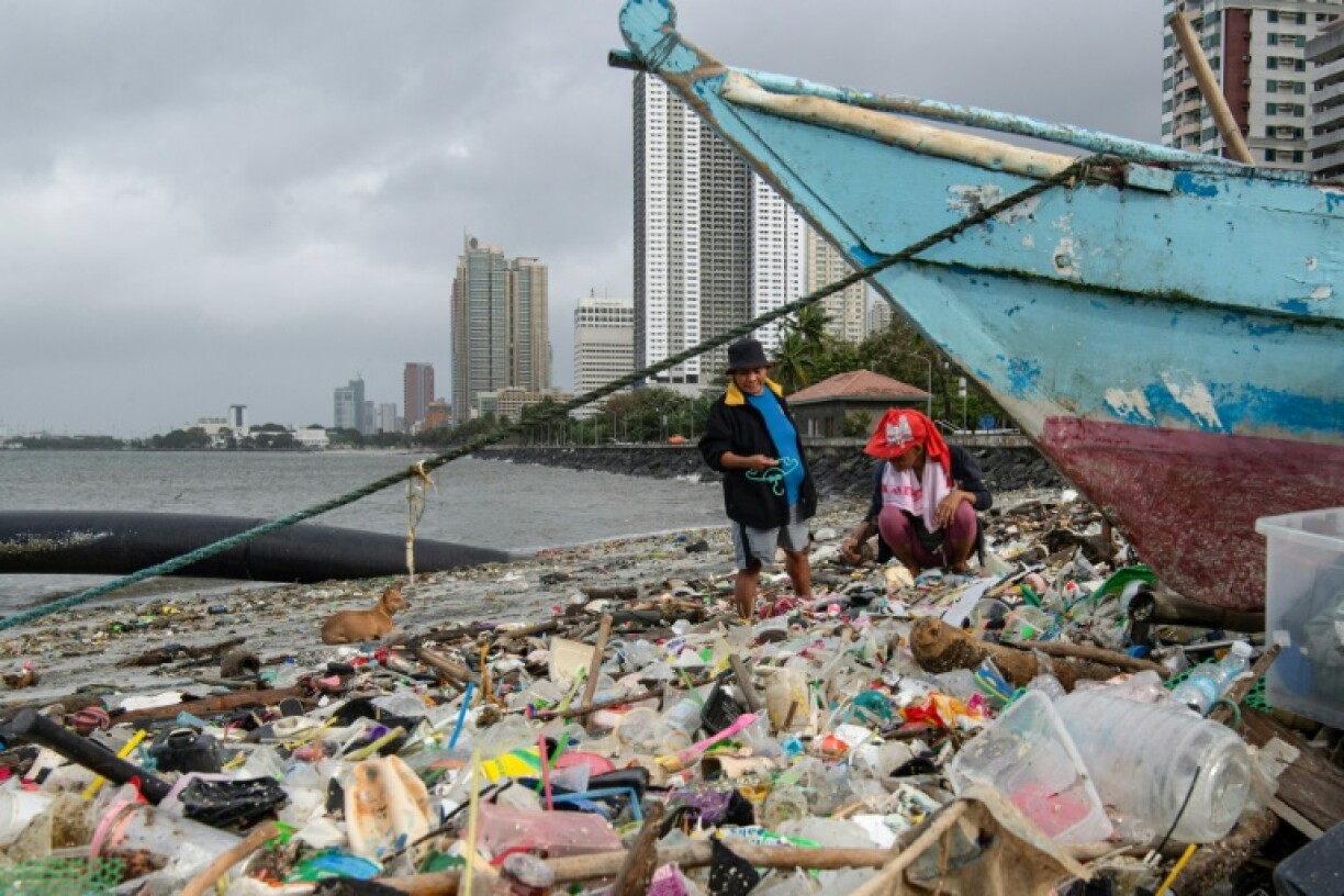 Manila residents look for recyclables after Typhoon Fung-wong swept trash ashore