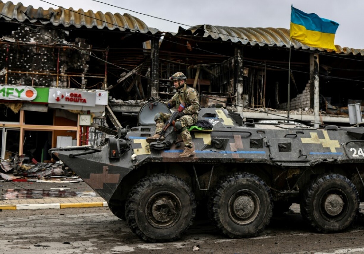 Un soldat ukrainien patrouille sur un tank à Boutcha, près de Kiev, le 2 avril 2022