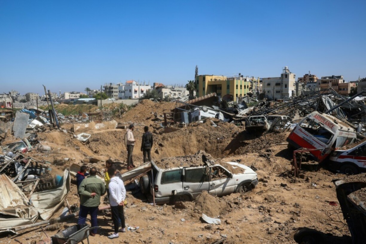 Palestinians inspect the damage at an ambulance repair yard hit by Israeli strikes in central Gaza
