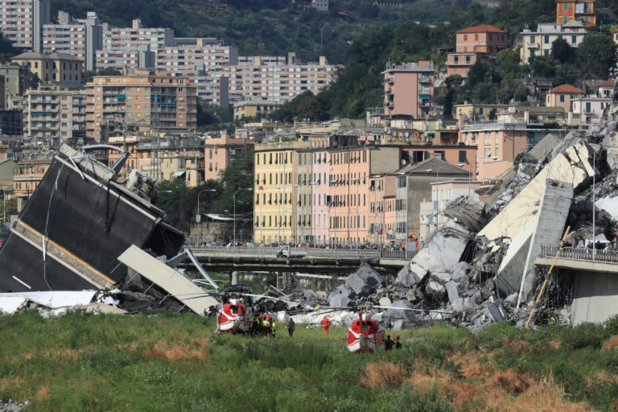 Des secouristes sur le site de l'effondrement du pont autoroutier Morandi à Gênes, le 14 août 2018 en Italie