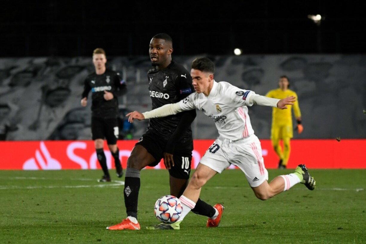 L'attaquant français de Mönchengladbach, Marcus Thuram (g), aux prises avec le milieu du Real Madrid, Sergio Arribas, lors du match de groupes de la Ligue des champions à Valdebebas, le 9 décembre 2020