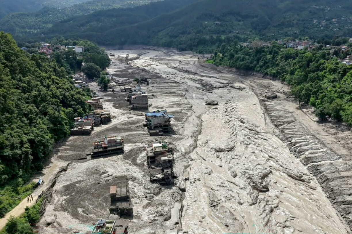 Des maisons sont partiellement submergées par une eau boueuse le long d'une rivière après des crues soudaines à Trishuli Bazar, dans le district de Nuwakot, au Népal, le 26 août 2026.