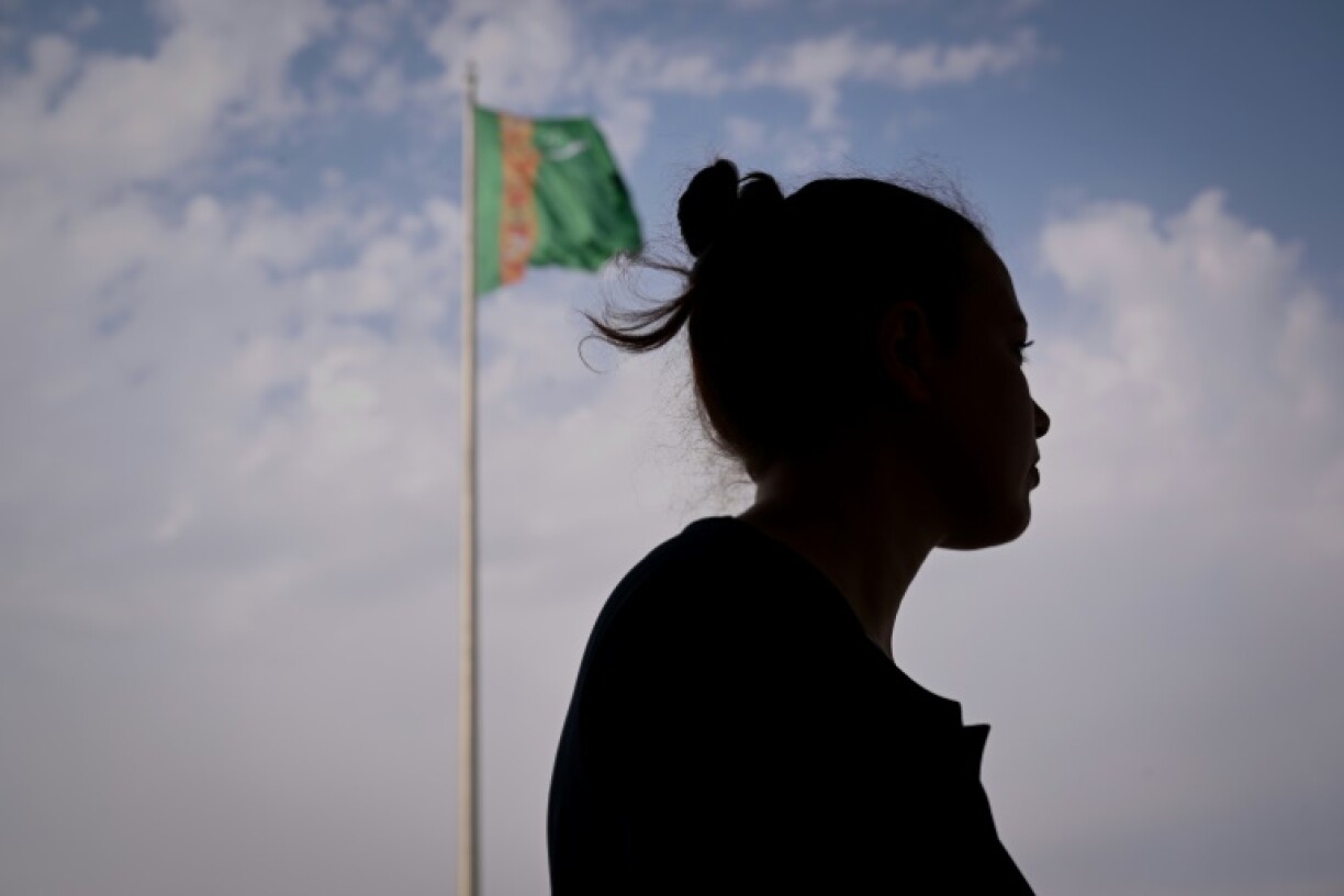 A woman pictured before the Turkmenistan flag in the capital, Ashgabat
