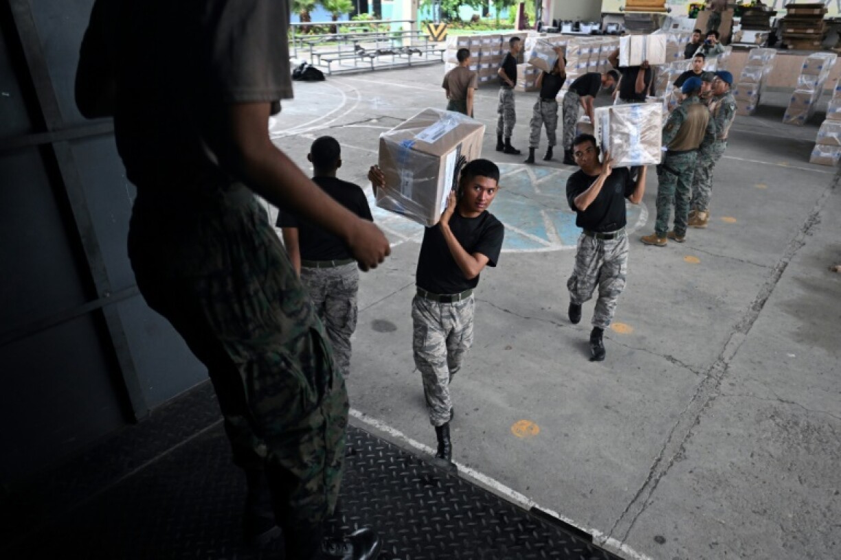Members of Ecuador's armed forces transport election materials at a processing center in the city of Duran on the eve of the 2025 presidential election