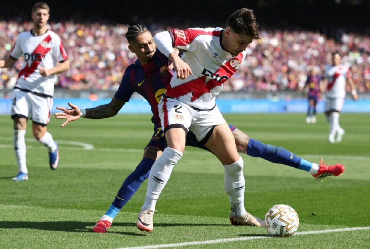 Le défenseur de Rayo Vallecano Andrei Ratiu au duel avec l'attaquant du FC Barcelone Raphinha, lors d'un match de Liga, le 22 mars 2026, à Barcelone