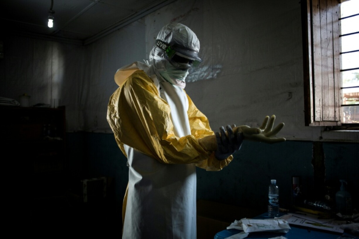 Un personnel de santé enfile son équipement de protection avant d'entrer dans la zone rouge d'un centre de traitement Ebola (CTE) soutenu par MSF, le 6 novembre 2018 à Bunia, en RDC