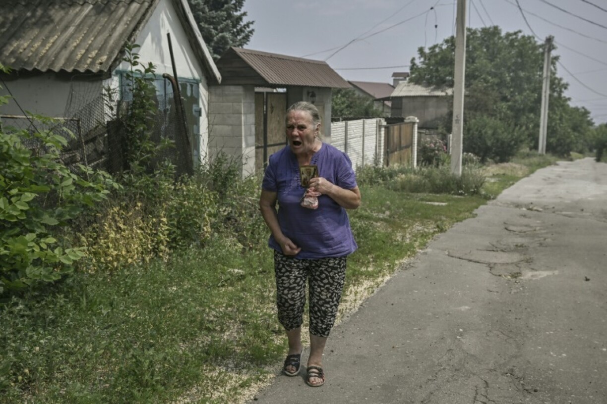 Une femme crie le 11 juin 2022 à Lyssytchansk, dans l'est de l'Ukraine, alors que troupes russes et ukrainiennes s'affrontent dans un duel d'artillerie