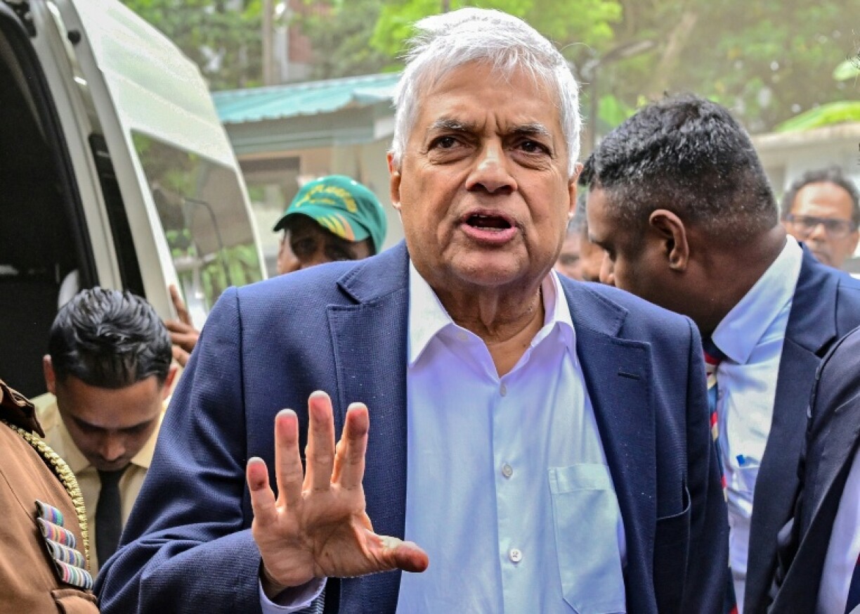 Sri Lanka's former president Ranil Wickremesinghe gestures as he arrives to appear before a court after his arrest