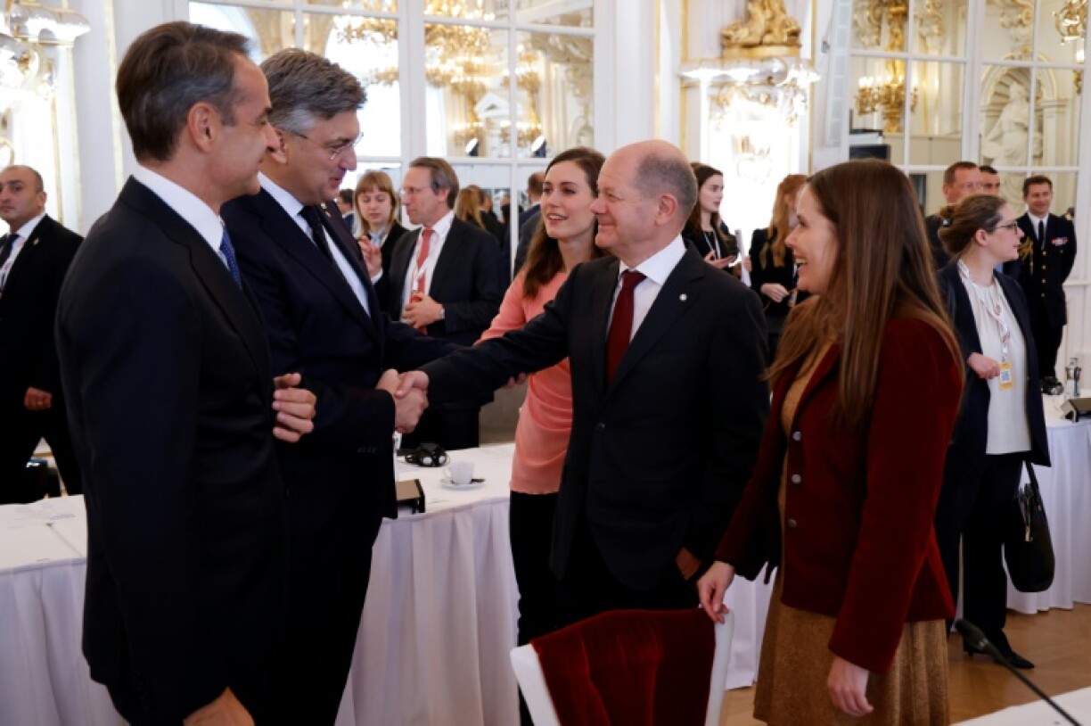 Le Pemier ministre grec Kyriakos Mitsotakis (gauche) parle avec le chancelier allemand Olaf Scholz (second à droite), notamment, à l'ouverture du sommet de la Communauté politique européenne, le 6 octobre 2022 à Prague (République tchèque)