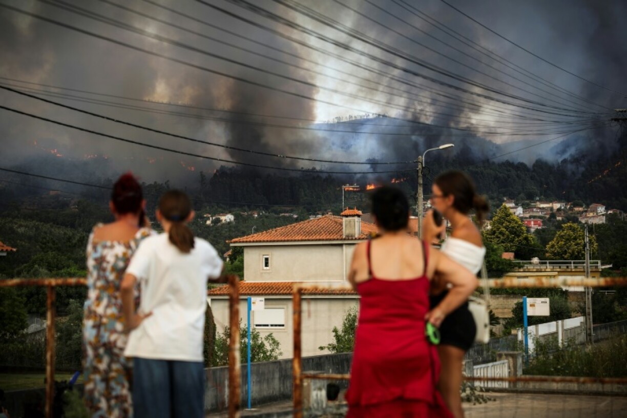 Residents watch as a wildfire burns in the surrounding hills in Gondomar, northern Portugal, on July 29, 2025