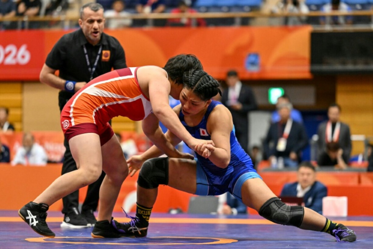 Japan's Ami Ishii (R) competes with North Korea's Pak Sol-gum in the women's wrestling 68kg final