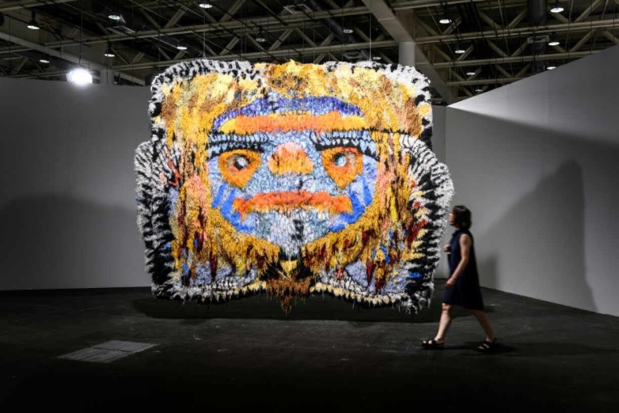A visitor walks past 'Gobbler' by Caroline Achaintre at Art Basel