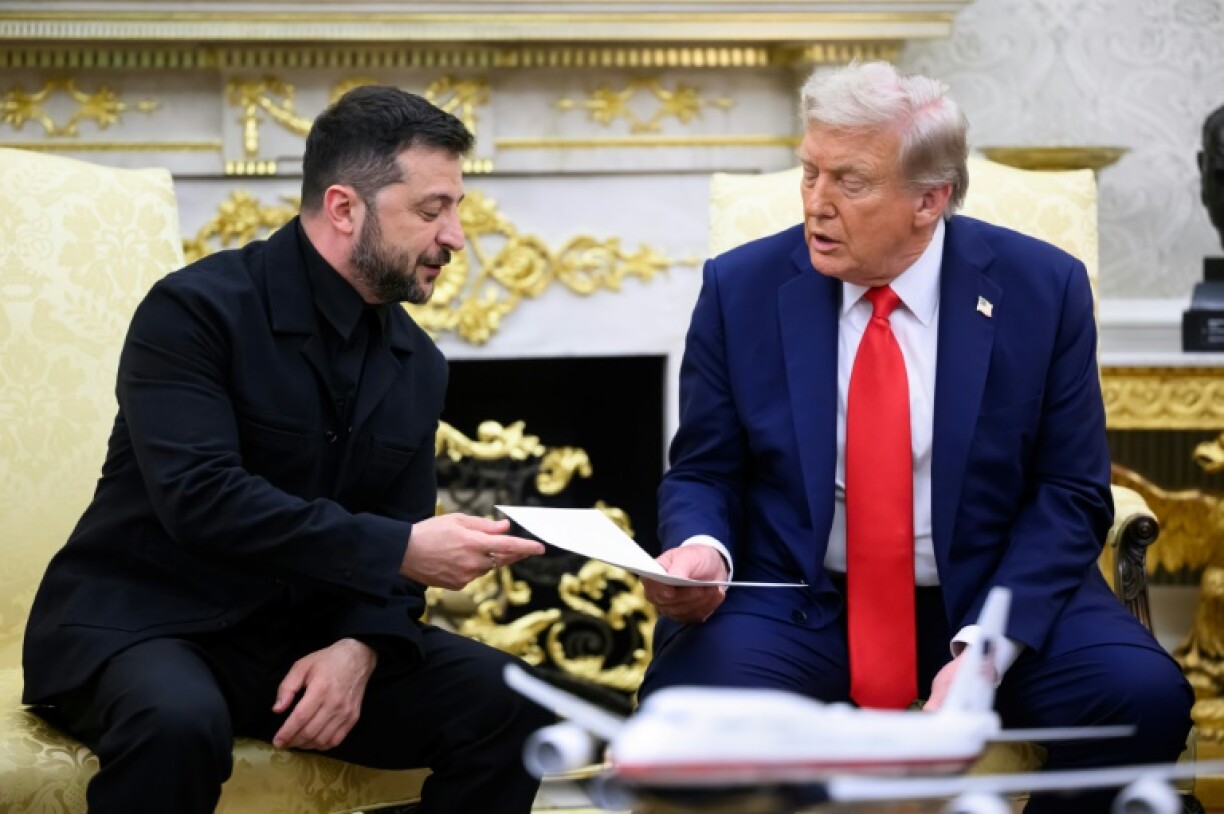 Ukraine President Volodymyr Zelensky hands a letter from his wife to US President Donald Trump