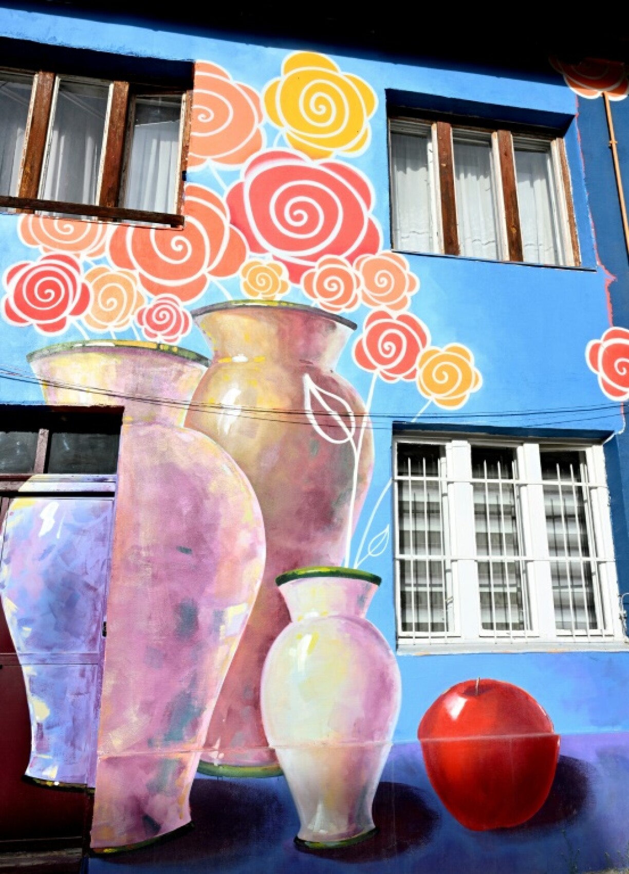 Old buildings renovated with murals in a city which still bears the physical scars of war three decades on