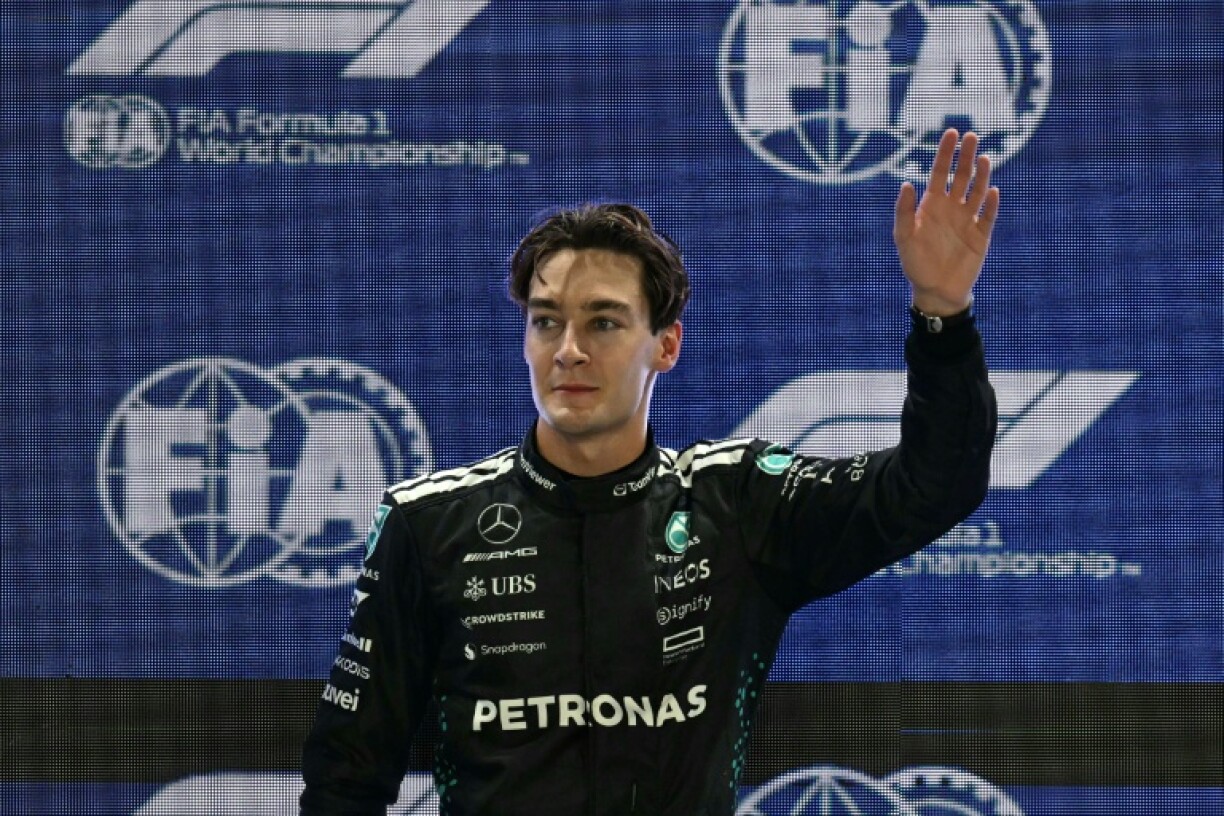Mercedes' British driver George Russell waves as he celebrates getting pole position