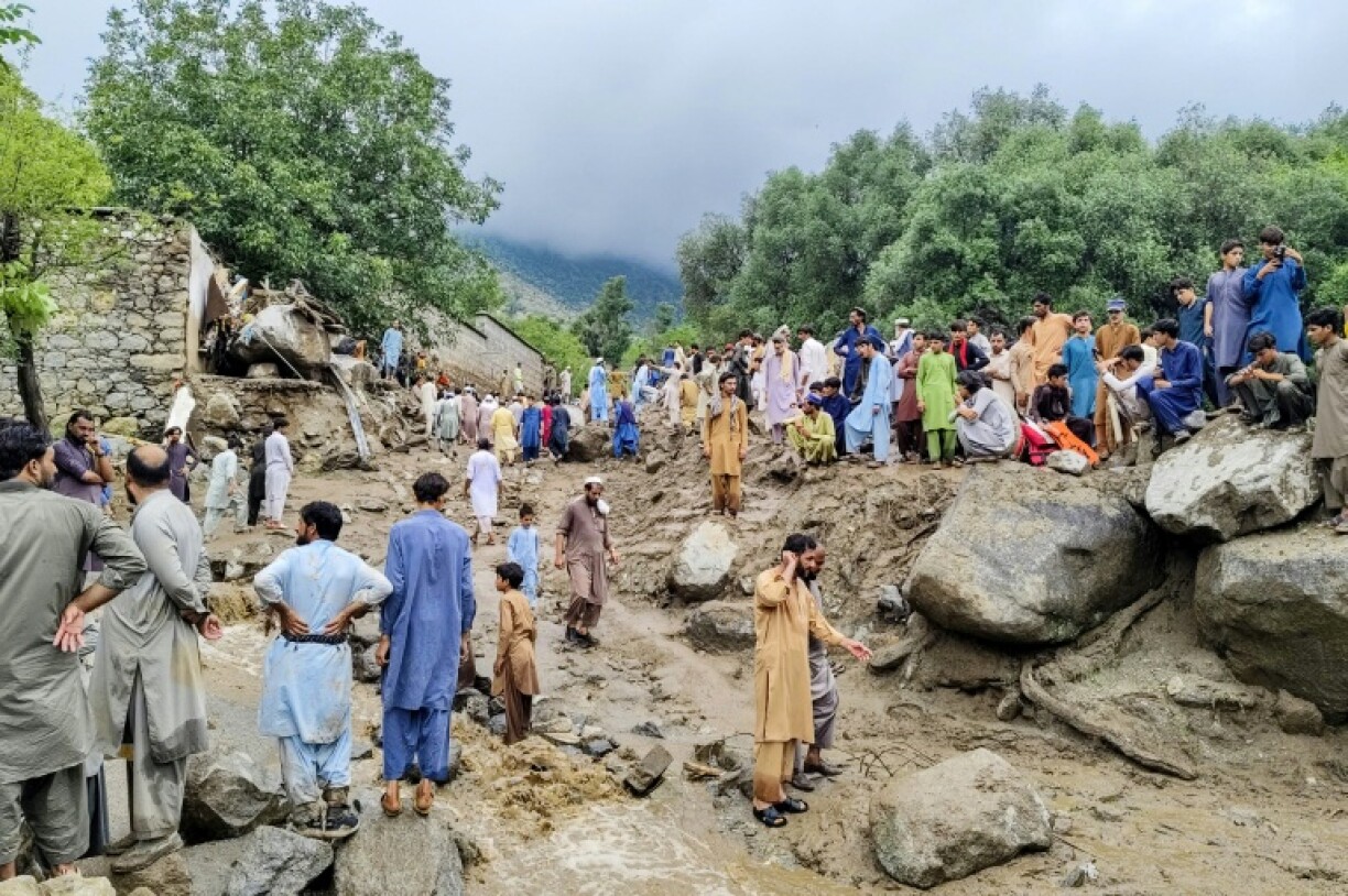 People gather at the site of a flash flood in Pakistan's Bajaur district
