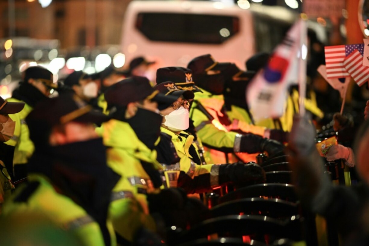Police officers set up barricades in front of people taking part in a rally to support South Korea's impeached president Yoon Suk Yeol