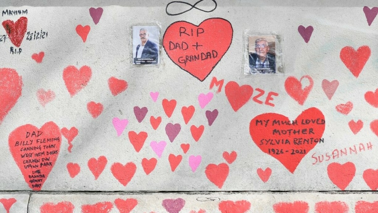 Red and pink hearts and messages are seen painted on the National Covid Memorial Wall on the embankment on the south side of the River Thames in London on April 8, 2021 in memory of those who lost their lives to Covid-19. Volunteers completed on April 8 a mural made up of roughly 150,000 hand-drawn red and pink hearts on a memorial wall by London's River Thames to remember the victims of the coronavirus crisis.