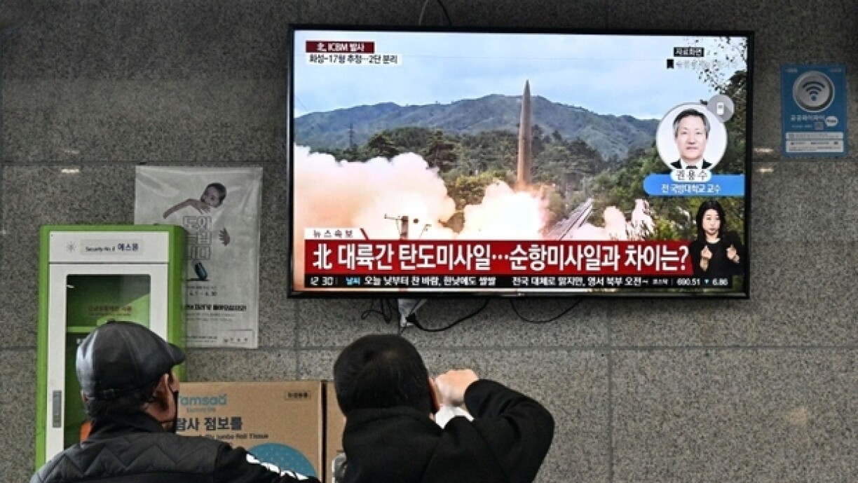 Des personnes regardent un écran de télévision montrant des images d'un missile tiré par la Corée du Nord, le 3 novembre 2022, à Ulleungdo (Corée du Sud)