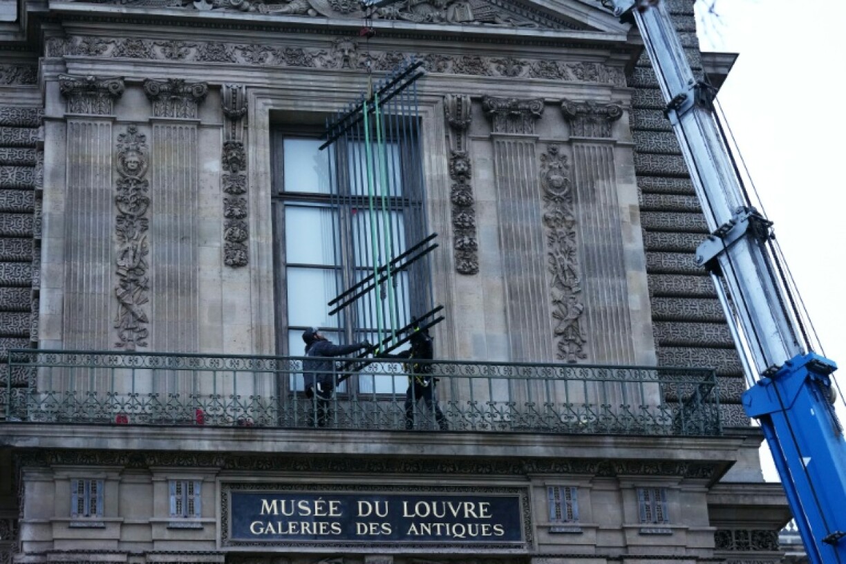 Des ouvriers installent une grille de protection devant la fenêtre de la galerie d'Apollon du musée du Louvre, le 23 décembre 2025 à Paris