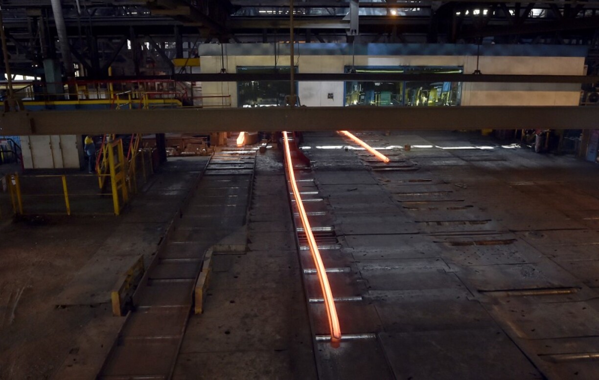 Une barre de fer rougeoyante sortant d'un four à l'usine British Steel d'Hayange.