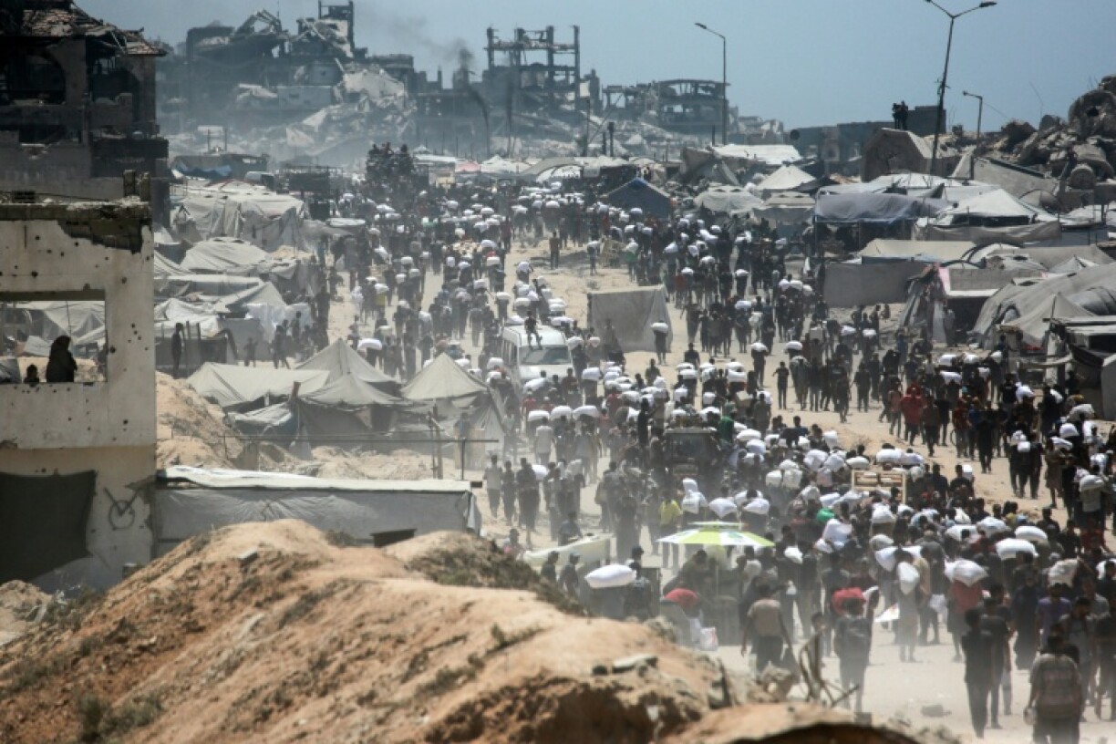 Palestinians carry bags of flour from aid trucks in the northern Gaza Strip