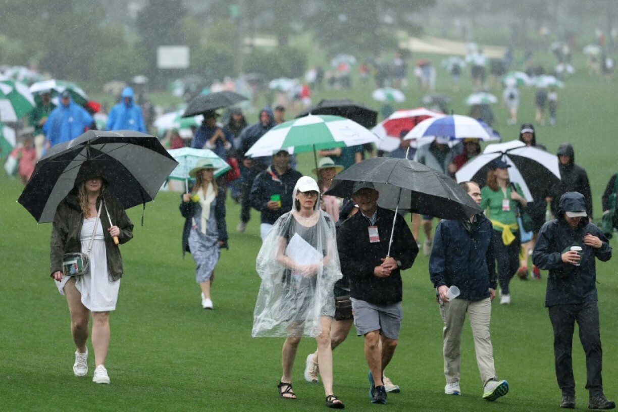 Spectators evacuate Augusta National Golf Club after the first practice round for the 89th Masters was suspended due to bad weather in the area