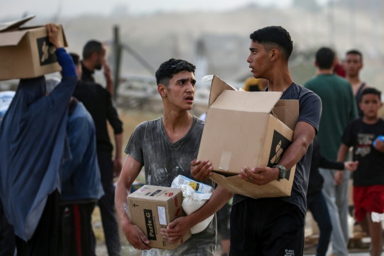 Palestinians carry food aid from the Gaza Humanitarian Foundation