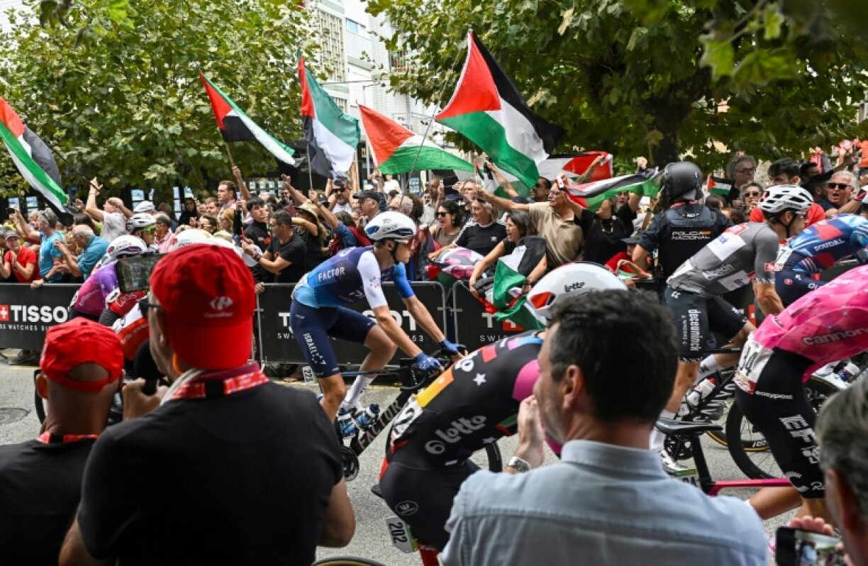 Team Israel Premier-Tech's Italian rider Marco Frigo rides next to pro-Palestinian demonstrators at the start of the 12th stage on Thursday