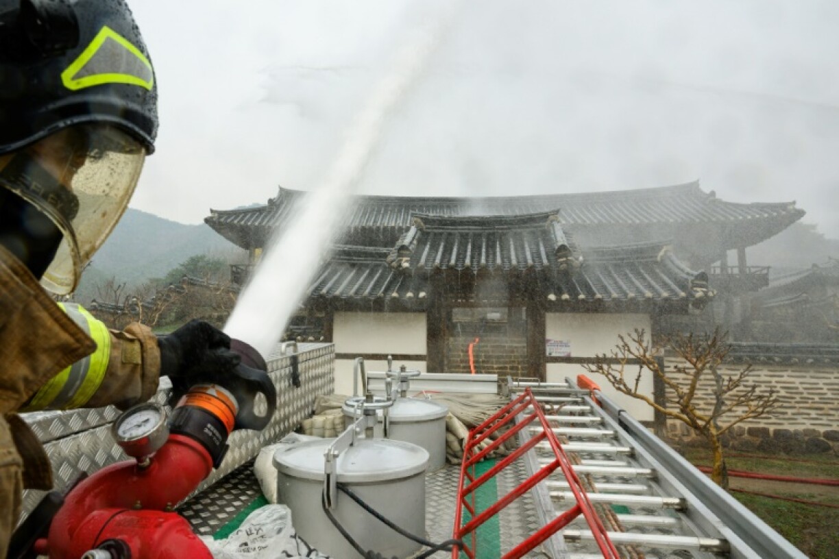 A firefighter sprays water onto the UNESCO-listed Byeongsan Seowon, a former Confucian academy, in a bid to save the historic site from approaching wildfires