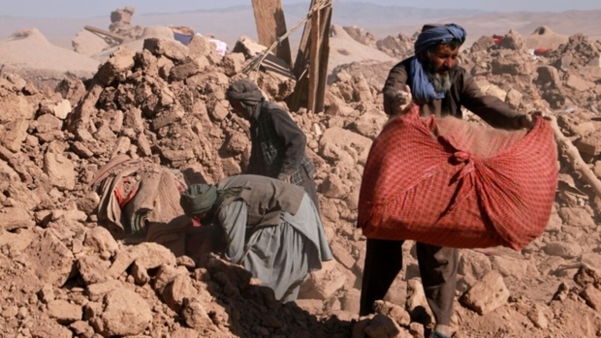 Les habitants nettoient les débris des maisons endommagées par un premier tremblement de terre dans la province de Herat, le 10 octobre 2023