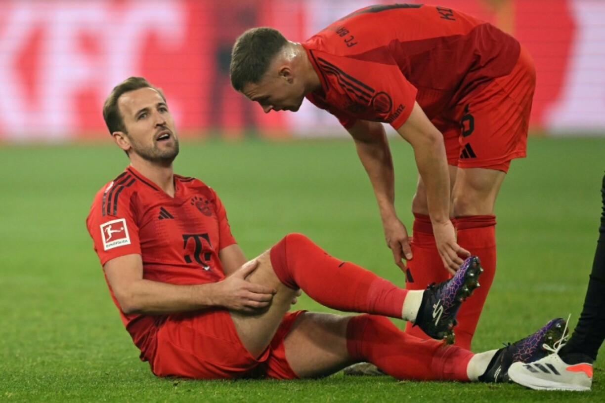 Bayern Munich forward Harry Kane (L) grabs his injured hamstring before being subbed off in Saturday's 1-1 draw with Borussia Dortmund