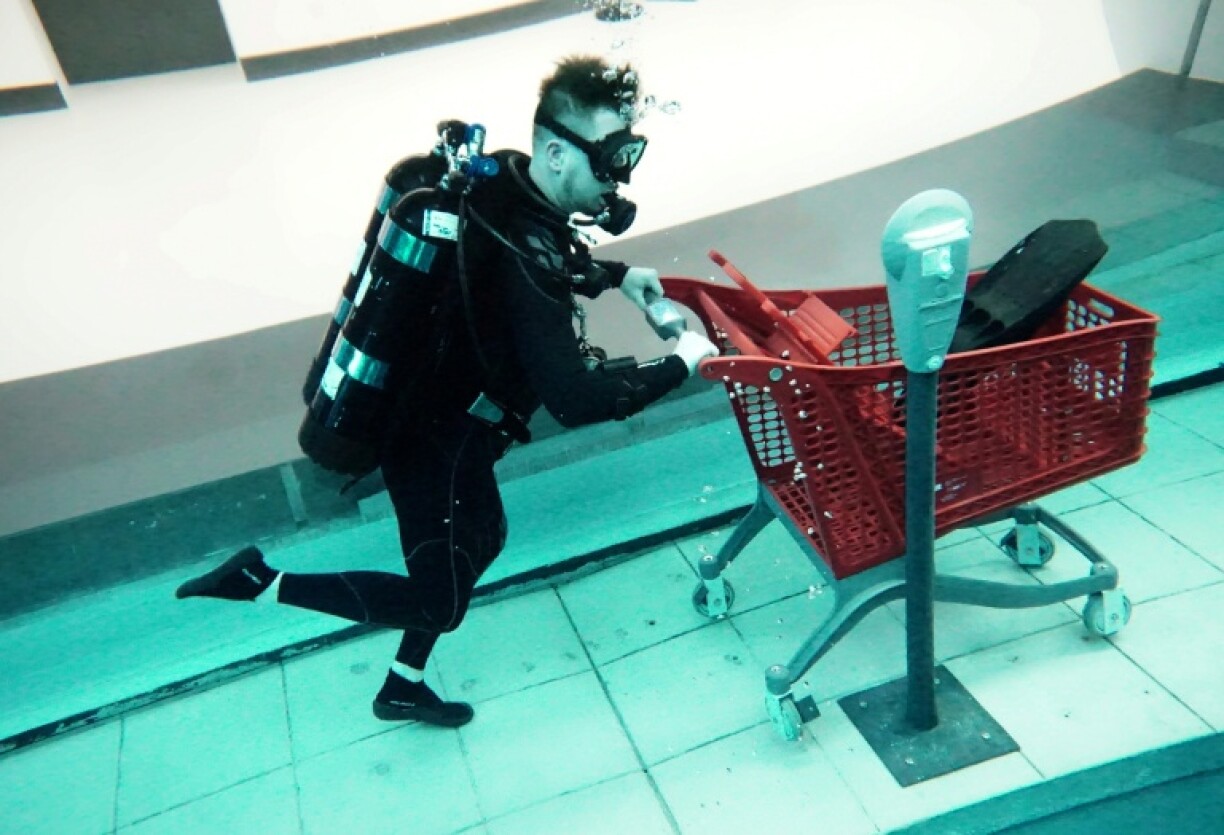A diver uses a mock shopping cart as he experiences the 'sunken city' of Deep Dive Dubai
