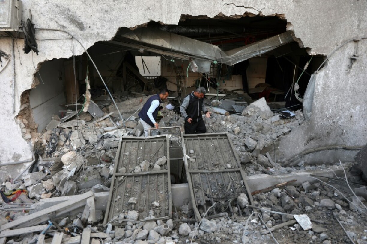 Des Palestiniens inspectent les destructions à la suite d'une frappe israélienne sur l'hôpital Al-Ahli dans la ville de Gaza, le 13 avril 2025